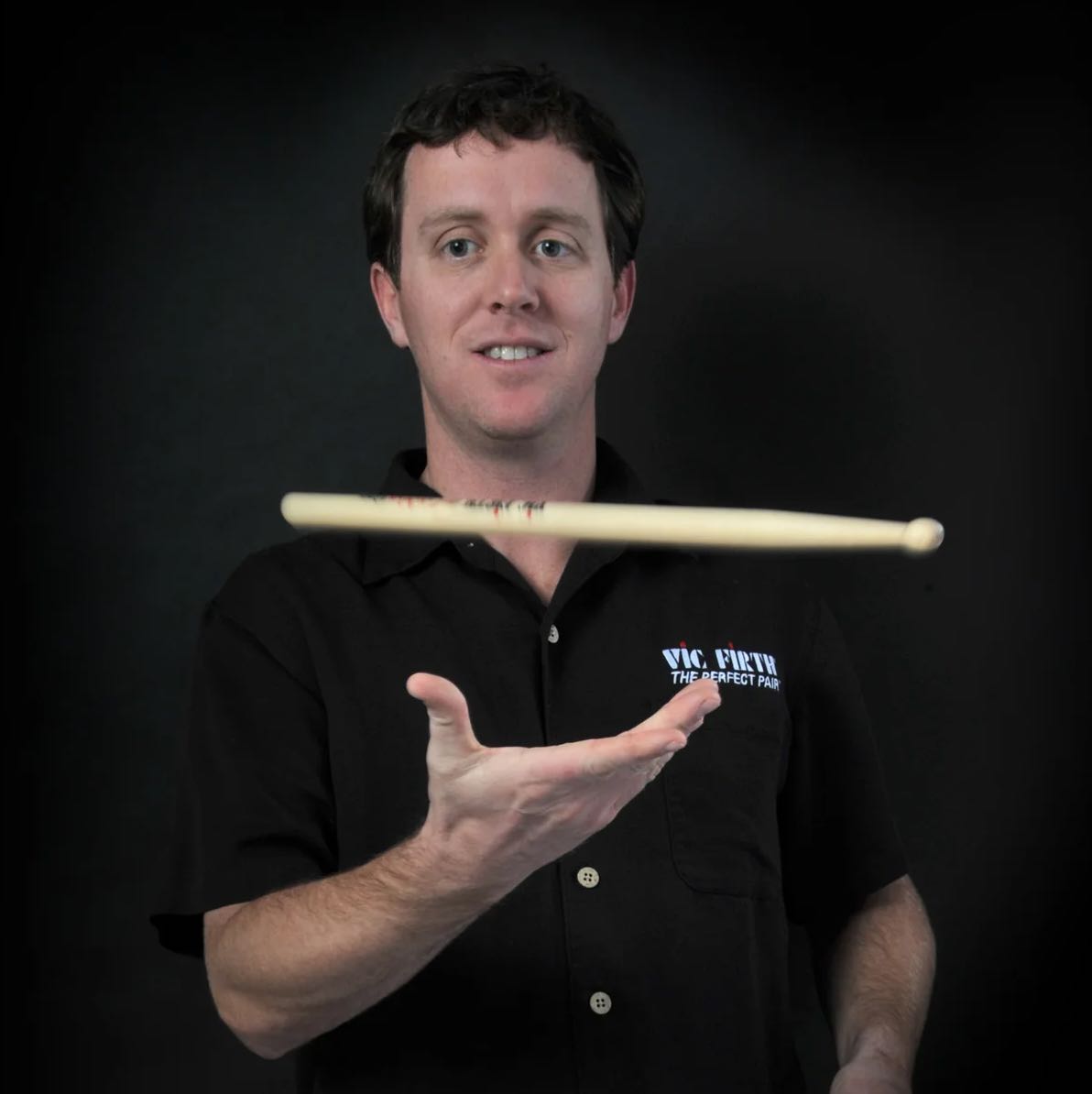 Headshot of Colin McNutt throwing a drum stick